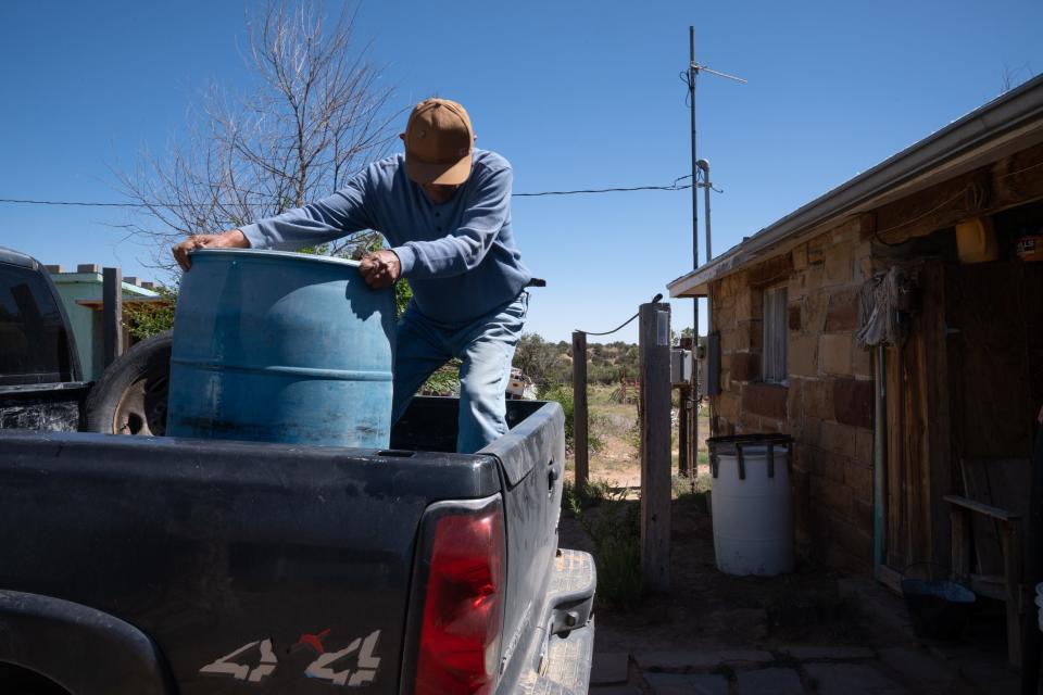 Percy Deal unloads a 55-gallon barrel of water, June 28, 2023, his home in the Big Mountain area of northeastern Arizona.