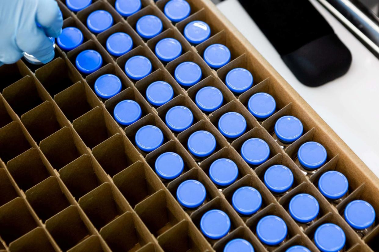 A lab technician loads bright stock filled vials of investigational coronavirus disease (COVID-19) treatment drug remdesivir: via Reuters