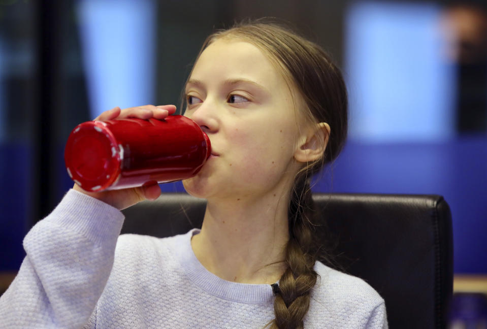 Swedish climate activist Greta Thunberg drinks from her re-usable bottle during a meeting of the Environment Council at the European Parliament in Brussels, Wednesday, March 4, 2020. Climate activists and Green members of the European Parliament are urging the European Union to be more ambitious as the bloc gets ready to unveil plans for a climate law to cut greenhouse gas emissions to zero by mid-century. (AP Photo/Olivier Matthys)