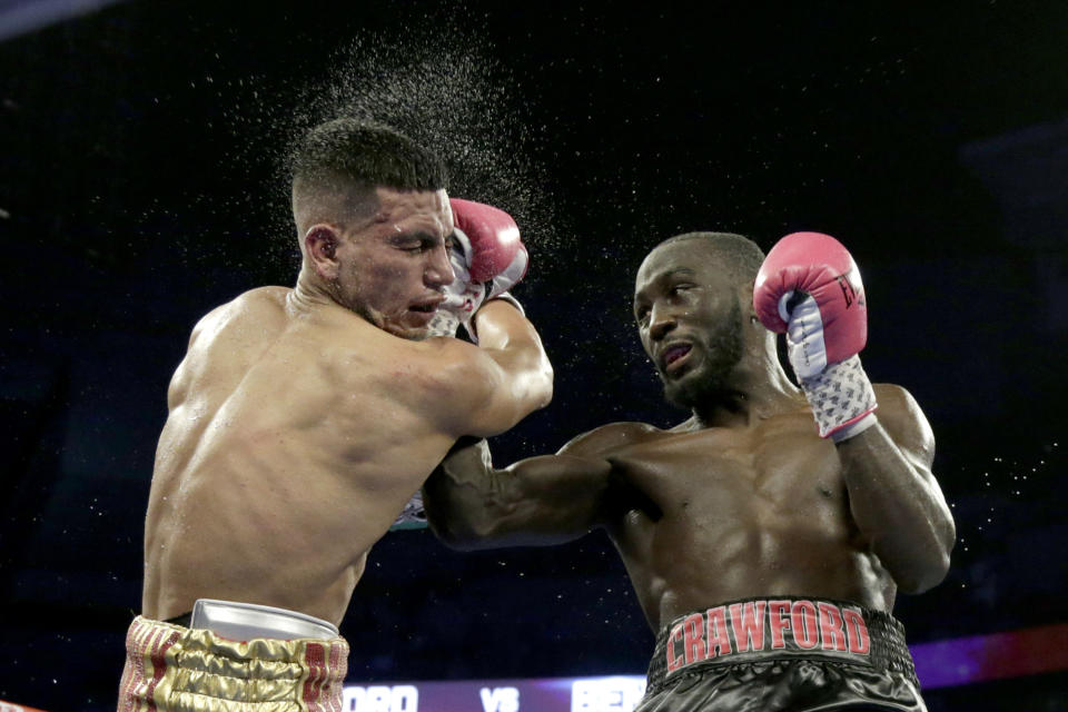 Terence Crawford, right, connects with Jose Benavidez during their WBO welterweight title boxing bout in Omaha, Neb., Saturday, Oct. 13, 2018. Crawford won in the 12th round. (AP Photo/Nati Harnik)