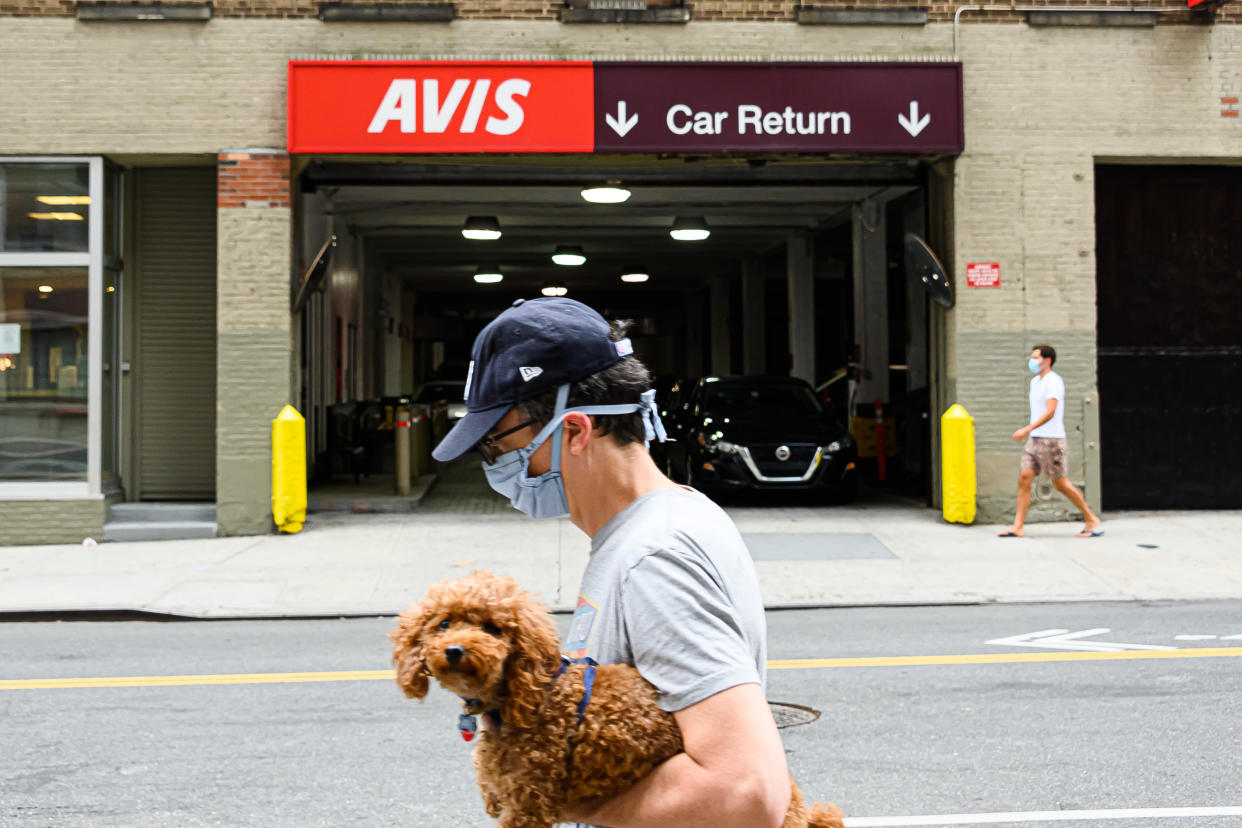 NEW YORK, NEW YORK - AUGUST 02: A person walks outside Avis car rental in Hell's Kitchen as the city continues Phase 4 of re-opening following restrictions imposed to slow the spread of coronavirus on August 2, 2020 in New York City. The fourth phase allows outdoor arts and entertainment, sporting events without fans and media production. (Photo by Noam Galai/Getty Images)