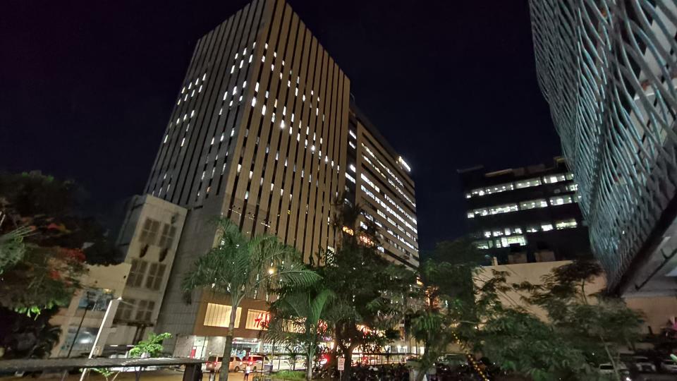 A cityscape featuring a large building with a prominent tower standing tall amidst the urban landscape