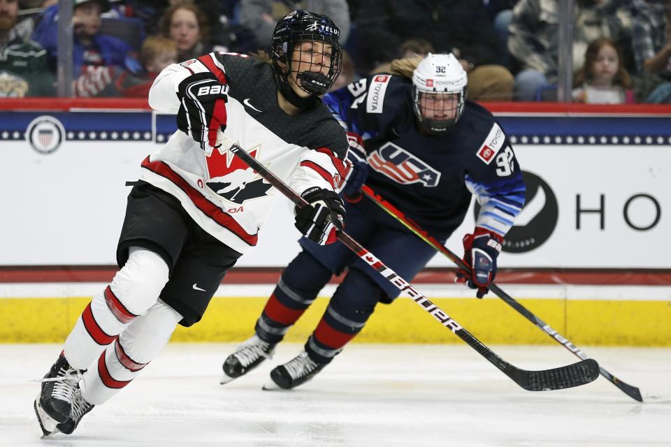 Canada's Rebecca Johnston, left, defends against United States' Kelly Browne (32) during the first period of a rivalry series women's hockey game in Hartford, Conn., Saturday, Dec. 14, 2019. (AP Photo/Michael Dwyer)