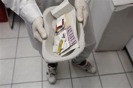 A paramedic holds a kit containing syringes, bandaids and antiseptic pads which are going to be used by drug addicts inside a supervised injection room in Athens November 25, 2013. REUTERS/Yorgos Karahalis