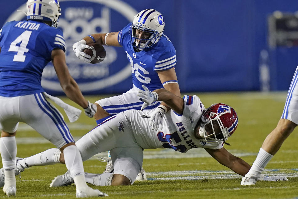 BYU tight end Carter Wheat, rear, is tackled by Louisiana Tech defensive lineman Mykol Clark (56) during the first half of an NCAA college football game Friday, Oct. 2, 2020, in Provo, Utah. (AP Photo/Rick Bowmer, Pool)