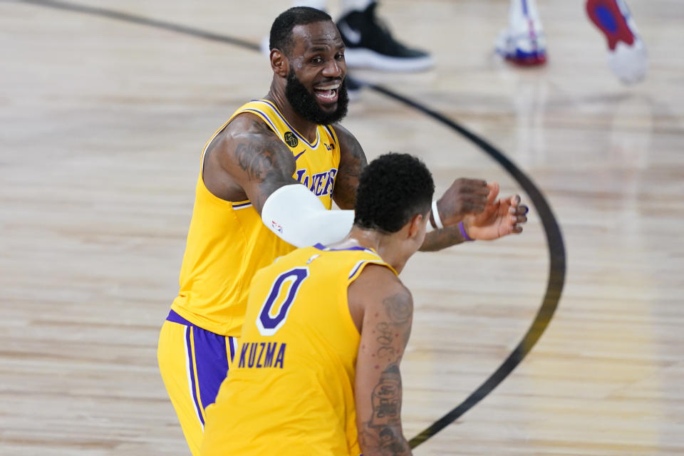 Los Angeles Lakers' Kyle Kuzma (0) is congratulated by LeBron James after hitting a game-winning 3-pointer against the Denver Nuggets during the second half of an NBA basketball game Monday, Aug. 10, 2020, in Lake Buena Vista, Fla. The Lakers won 124-121. (AP Photo/Ashley Landis, Pool)