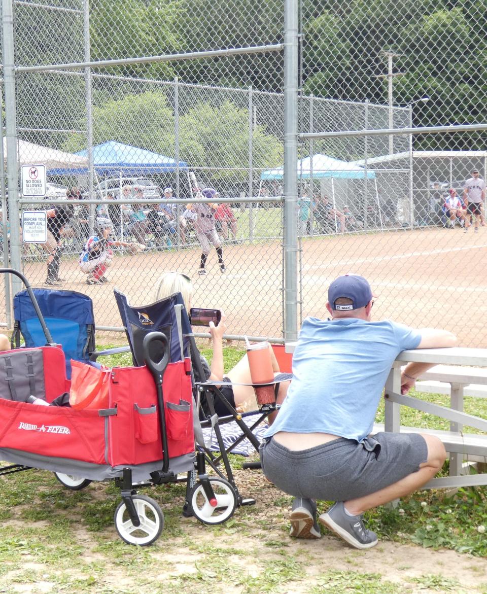 A spectator watches a game at Aumiller Park on Saturday during this weekend's Tommy Slugfest.