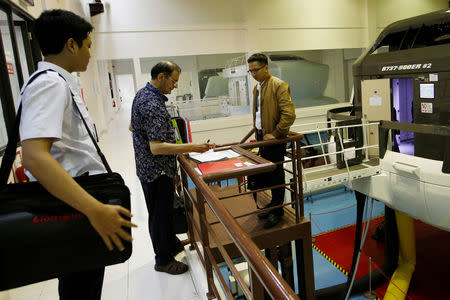 A senior instructor of Lion Air Group writes in a report book as he supervises the aviation students after a Jet Introduction session in Boeing 737-900ER simulator at Angkasa Training Center near Jakarta, Indonesia, November 2, 2018. REUTERS/Willy Kurniawan