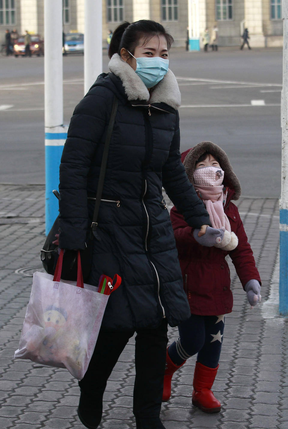 A girl and her mother walk on the street near the Pyongyang railway station in Pyongyang, North Korea, Thursday, Jan. 27, 2022. (AP Photo/Jon Chol Jin)