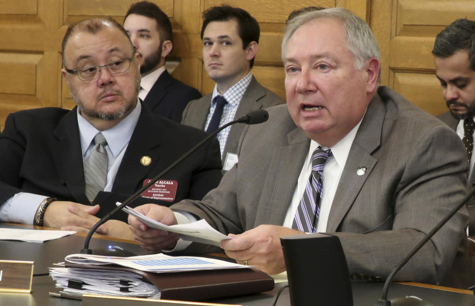 Kansas Senate Majority Leader Jim Denning, right, R-Overland Park, asks questions during a briefing on Democratic Gov. Laura Kelly's budget proposals as state Rep. John Alcala, left, D-Topeka, watches, Thursday, Jan. 17, 2019, at the Statehouse in Topeka, Kan. Denning is critical of a Kelly proposal to lower annual payments to the state pension system for teachers and government workers. (AP Photo/John Hanna)