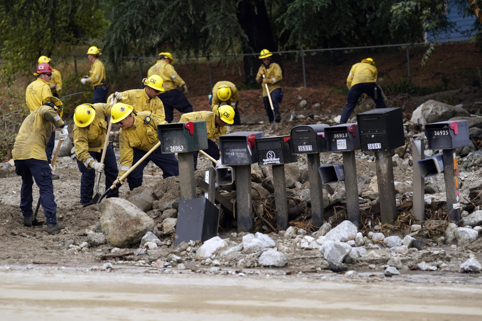 Members of Cal Fire Pilot Rock 6 crew out of Crestline, Calif., clear mud off the side of the road in the aftermath of Tropical Storm Hilary Monday, Aug. 21, 2023, in Yucaipa, Calif. (AP Photo/Marcio Jose Sanchez)