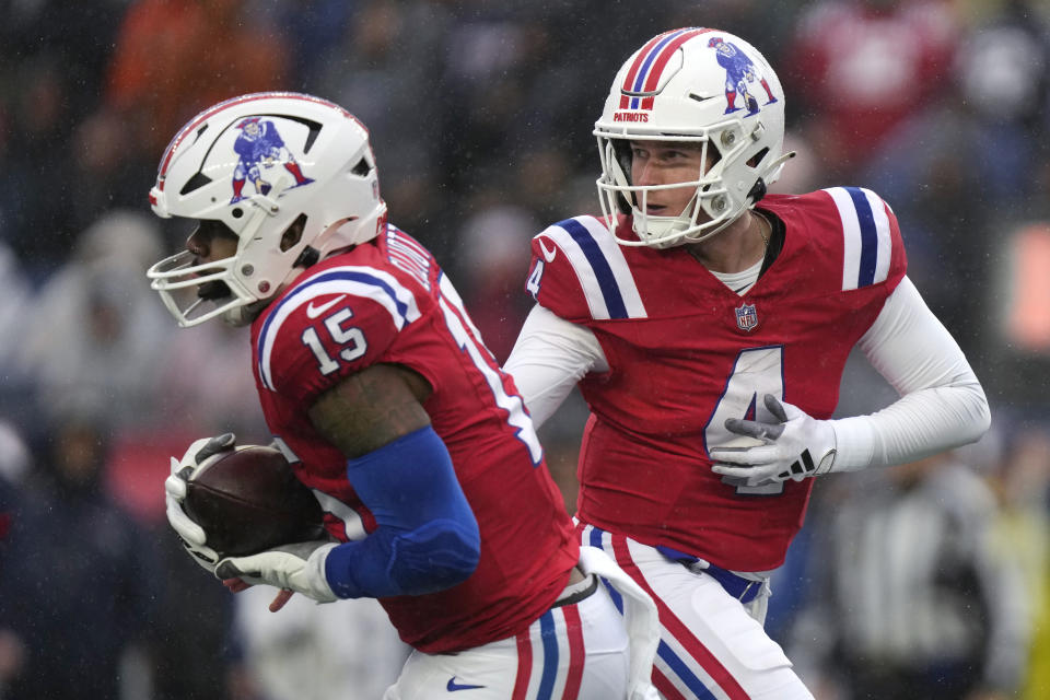 New England Patriots quarterback Bailey Zappe (4) hands off to running back Ezekiel Elliott (15) during the first half of an NFL football game, Sunday, Dec. 3, 2023, in Foxborough, Mass. (AP Photo/Steven Senne)