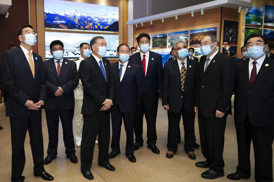 In this photo released by Xinhua News Agency, Wang Yang, third of left, chairman of the Chinese People's Political Consultative Conference (CPPCC) is escorted by officials as he visits to a museum period of the ceremony to commemorate the 70th anniversary of Tibet liberation, in Lhasa in western China's Tibet Autonomous Region on Wednesday, Aug. 18, 2021. The top Chinese official said Thursday that “all-round efforts” are needed to ensure Tibetans speak standard spoken and written Chinese and share the “cultural symbols and images of the Chinese nation.” (Huang Jingwen/Xinhua via AP)