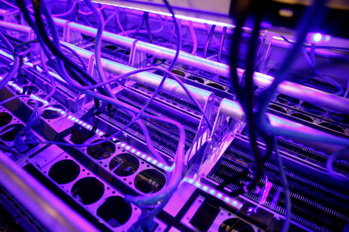 Cryptocurrency miners are seen in a liquid immersion cooling mining tank at the TMG Core stand during the Bitcoin Conference 2022 in Miami Beach, Florida, U.S. April 6, 2022. REUTERS/Marco Bello