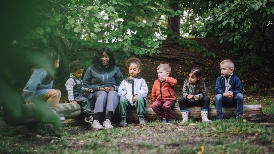 Wrap aroudn care illustrated by kids all sat in a line on a log outside