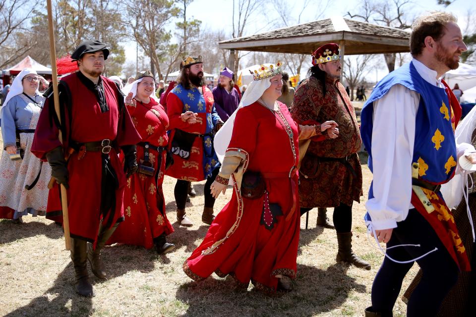 People dressed in period clothing walk April 1, 2022, along the grounds of the annual Medieval Fair at Reaves Park in Norman.