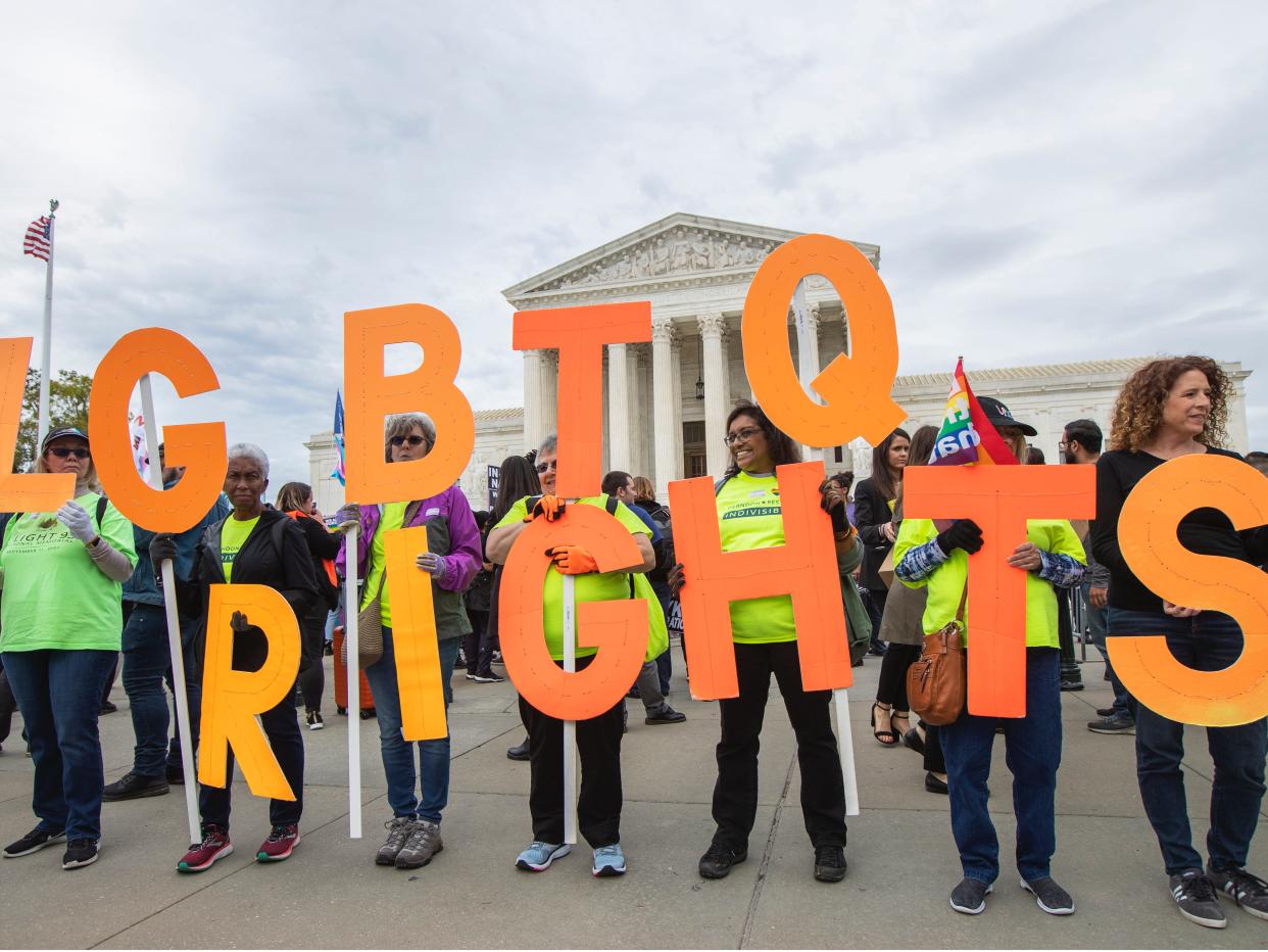 Supporters of LGBTQ rights hold placards in front of the U.S. Supreme Court, Tuesday, Oct. 8, 2019, in Washington. The Supreme Court heard arguments in its first cases on LGBT rights since the retirement of Justice Anthony Kennedy. (AP Photo/Manuel Balce Ceneta)