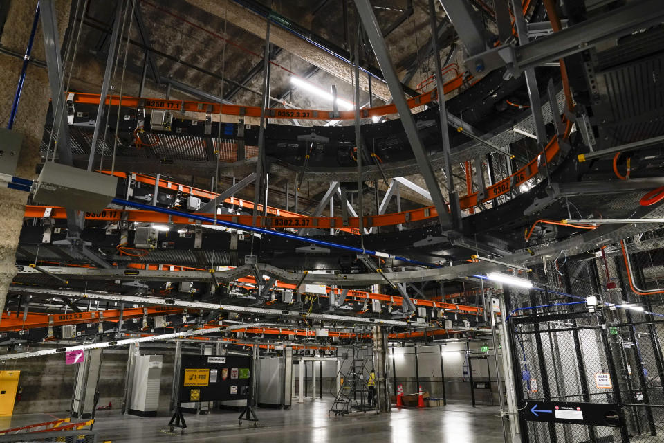 An automated storage and retrieval baggage handling system uses plastic trays with radio-frequency tags to track and store passengers' bags at the new West Gates at Tom Bradley International Terminal at Los Angeles International Airport Monday, May 24, 2021, in Los Angeles. The system will allow travelers to check in bags up to 24 hours in advance of their flight. (AP Photo/Ashley Landis)