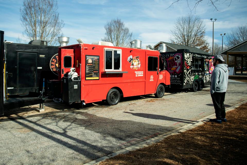 A man reads the menu at Too Sauc'd Up food truck at Scuffletown Food Truck Park in Simpsonville on Friday, Jan. 5, 2024.