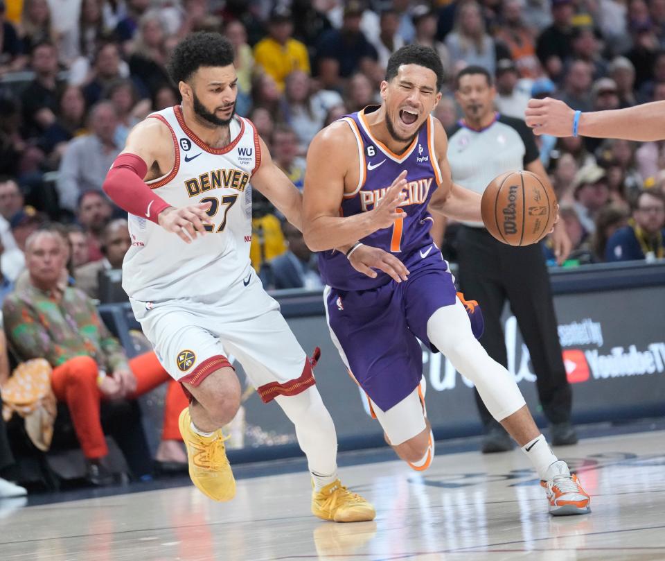 Phoenix Suns guard Devin Booker (1) drives against Denver Nuggets guard Jamal Murray (27) during the first quarter of the Western Conference semifinals at Ball Arena in Denver on May 9, 2023.