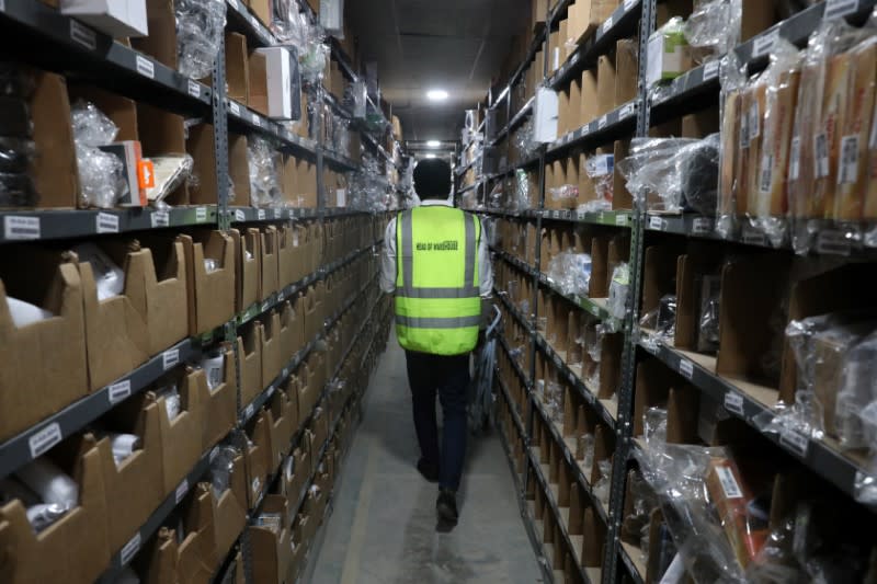 Worker of the Jumia warehouse walks between shelves in Lagos