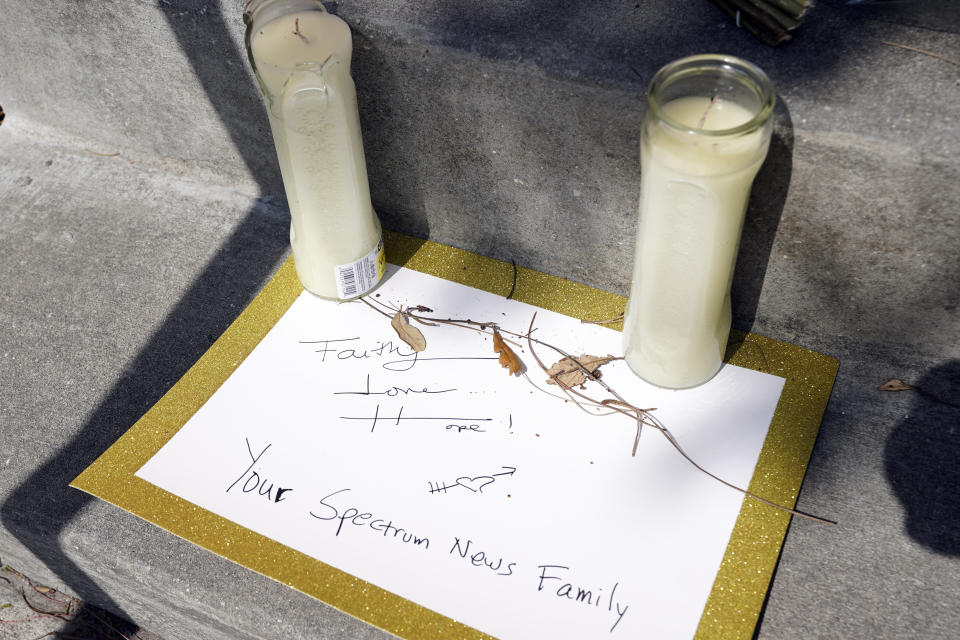 A note left by someone at the Spectrum News 13 TV station is seen at a makeshift memorial in front of the emergency room at Orlando Regional Medical Center Thursday, Feb. 23, 2023, in Orlando, Fla. A TV journalist and a child were shot and killed yesterday and several others were injured at a scene where a woman was found murdered earlier in the day. (AP Photo/John Raoux)