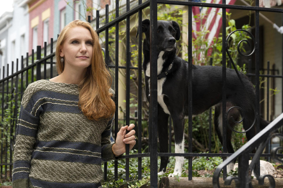 American Airlines flight attendant Allie Malis stands outside her home with her dog Piper on Friday, Sept. 25, 2020 in Washington. About 40,000 workers in the airline industry are facing layoffs on Thursday, Oct. 1, unless Congress comes up with another aid package. “At this point I don’t have a Plan B,” she said, pointing out that restaurant and other jobs that laid-off workers usually get to make it through a downturn don’t exist in this crisis. (AP Photo/Kevin Wolf)