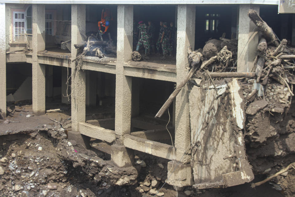 Rescue inspect the damage by a flash flood in Tanah Datar, West Sumatra, Indonesia, Wednesday, May 15, 2024. Indonesian authorities seeded clouds on Wednesday, trying to prevent further rain and flash floods after deluges that hit the country's Sumatra Island over the weekend left a number of people dead and missing. (AP Photo/Ali Nayaka)