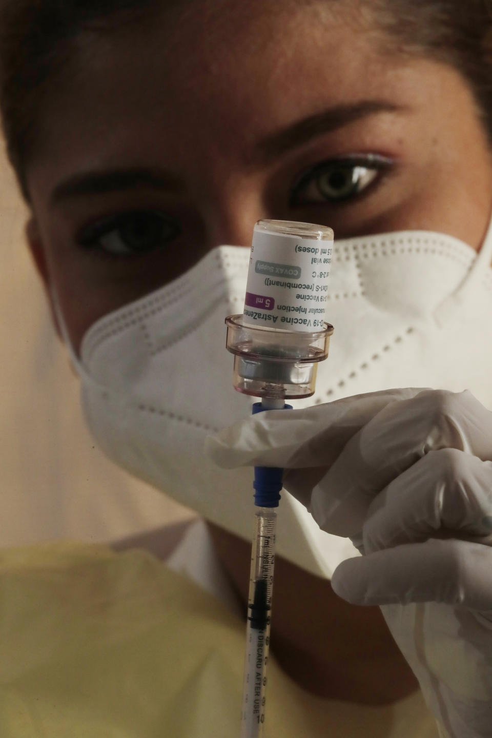 A nurse prepares a dose of the AstraZeneca vaccine for COVID-19 while giving vaccination shots to residents at the Rommel Fernandez soccer stadium parking lot in Panama City, Thursday, April 22, 2021. (AP Photo/Arnulfo Franco)