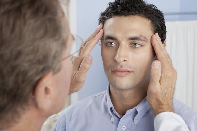 ADAM GAULT/SPL/Getty Images A doctor examines a patient’s eyes.