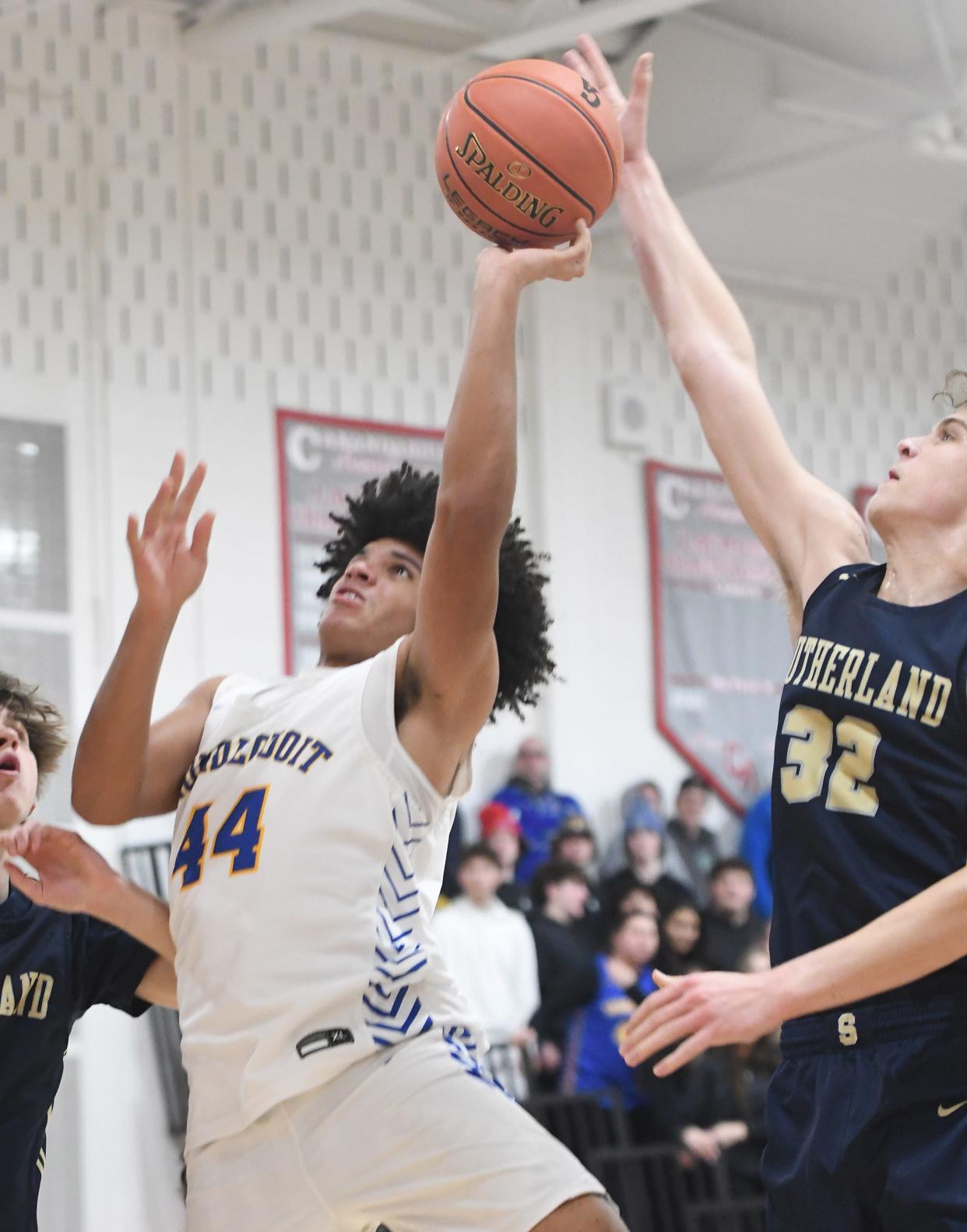 Max Michalski of Pittsford Sutherland tries to get a piece of a shot from Irondequoit's Isaiah Ballard.