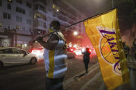 A Los Angeles Lakers fan celebrates outside of Staples Center after the Lakers defeated the Miami Heat in Game 6 of basketball's NBA Finals to win the championship. (AP Photo/Christian Monterrosa)