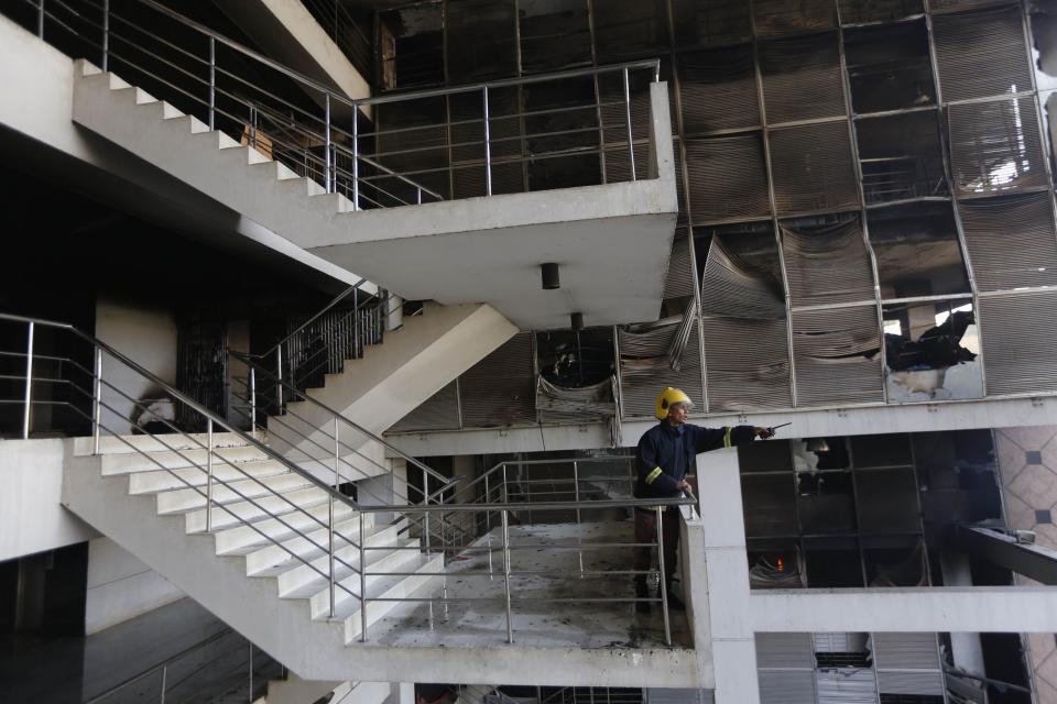 A firefighter inspects the damage at a Standard Group garment factory which was on fire in Gazipur