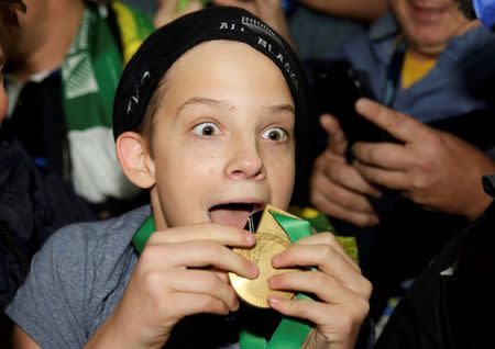 A boy displays the winners' medal given to him by Sonny Bill Williams of New Zealand after the Rugby World Cup Final against Australia at Twickenham in London, October 31, 2015. REUTERS/Henry Browne