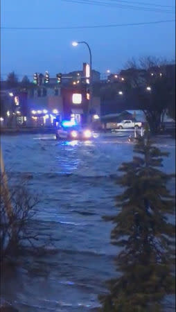 A police car is seen as floodwaters flow along a street in Pullman, Washington, U.S. in this still image taken from April 9, 2019 social media video. ELLIE STENBERG/via REUTERS