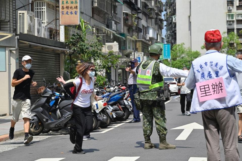 Military personnel guide local residents to take shelter during the Wanan Air Raid Drill, a civilian air-raid drill held on the same day of the annual Han Kuang military exercises, in Taipei on July 25, 2022.