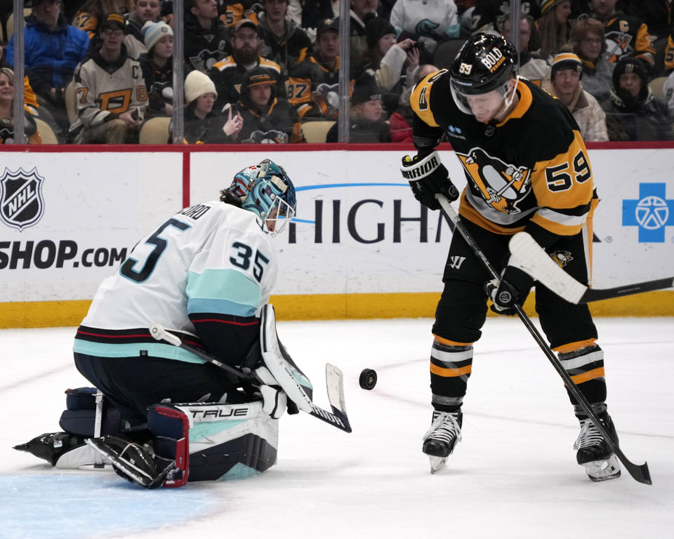 Seattle Kraken goaltender Joey Daccord (35) blocks a shot with Pittsburgh Penguins' Jake Guentzel unable to get his stick on the rebound during the second period of an NHL hockey game in Pittsburgh, Monday, Jan. 15, 2024. (AP Photo/Gene J. Puskar)