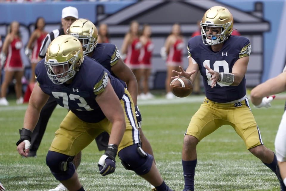 Notre Dame quarterback Drew Pyne taks a snap from center in the shotgun formation during the second half of an NCAA college football game against Wisconsin Saturday, Sept. 25, 2021, in Chicago. Notre Dame won 41-13. (AP Photo/Charles Rex Arbogast)