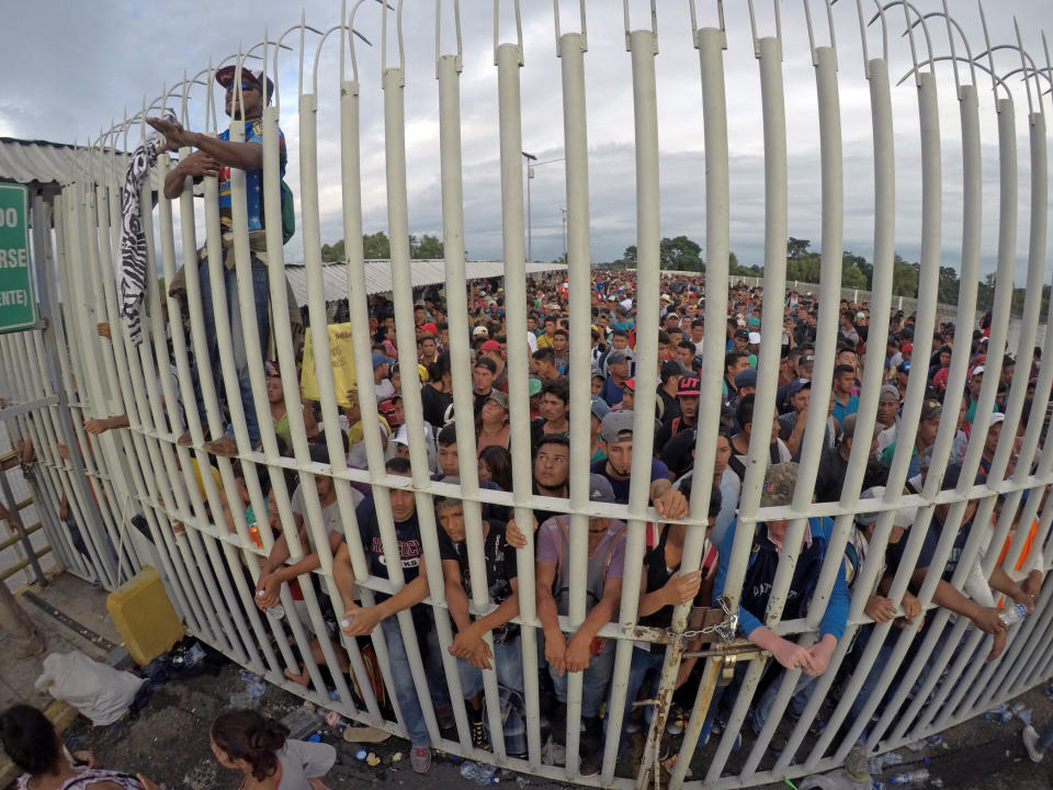 CIUDAD HIDALGO (MÉXICO),19/10/2018.- Migrantes hondureños esperan acceso sobre el puente que atraviesa el río Suchiate después de sobrepasar la valla en la frontera con Guatemala para ingresar a México hoy, viernes 19 de octubre de 2018, en Ciudad Hidalgo (México). Miles de migrantes de la caravana que partió el sábado pasado de Honduras forzaron hoy la valla fronteriza desde Guatemala e ingresaron a México, donde las fuerzas de seguridad se vieron en un primer momento rebasadas por un imparable río humano. EFE/María de la Luz Ascencio