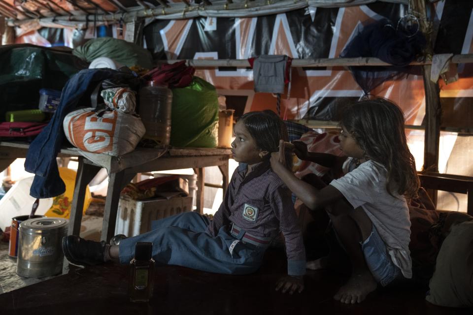 Garima Kumar, 10, right, combs the hair of her younger sister Arima, 7, as she prepares for school inside their shanti on the flood plain of Yamuna River, in New Delhi, India, Friday, Sept. 29, 2023. Their family was among those that were displaced by the recent floods in the Indian capital's Yamuna River. (AP Photo/Altaf Qadri)