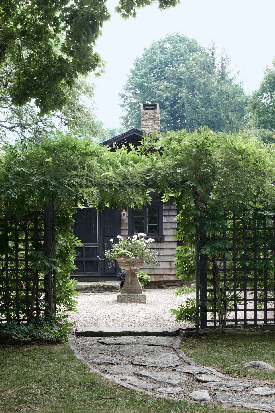 <p>Framed by wisteria, a Grecian- style planter holds a tangle of geraniums and sweet-potato vines outside of this Rhode Island home.</p><p><strong><a href="https://www.countryliving.com/home-design/house-tours/g1125/carefully-cultivated-home/" rel="nofollow noopener" target="_blank" data-ylk="slk:Read more about this carefully cultivated home;elm:context_link;itc:0;sec:content-canvas" class="link ">Read more about this carefully cultivated home</a>.</strong></p><p><a class="link " href="https://go.redirectingat.com?id=74968X1596630&url=https%3A%2F%2Fwww.wayfair.com%2FFleur-De-Lis-Living--Giroux-Concrete-Urn-Planter-X111660732-L349-K%7EW000559621.html&sref=https%3A%2F%2Fwww.countryliving.com%2Fgardening%2Fgarden-tours%2Fg1432%2Flandscaping-ideas%2F" rel="nofollow noopener" target="_blank" data-ylk="slk:SHOP STONE PLANTERS;elm:context_link;itc:0;sec:content-canvas">SHOP STONE PLANTERS</a></p>