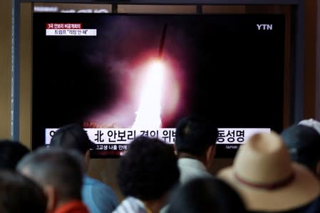 People watch a TV showing a file picture of a North Korean missile for a news report on North Korea firing short-range ballistic missiles, in Seoul