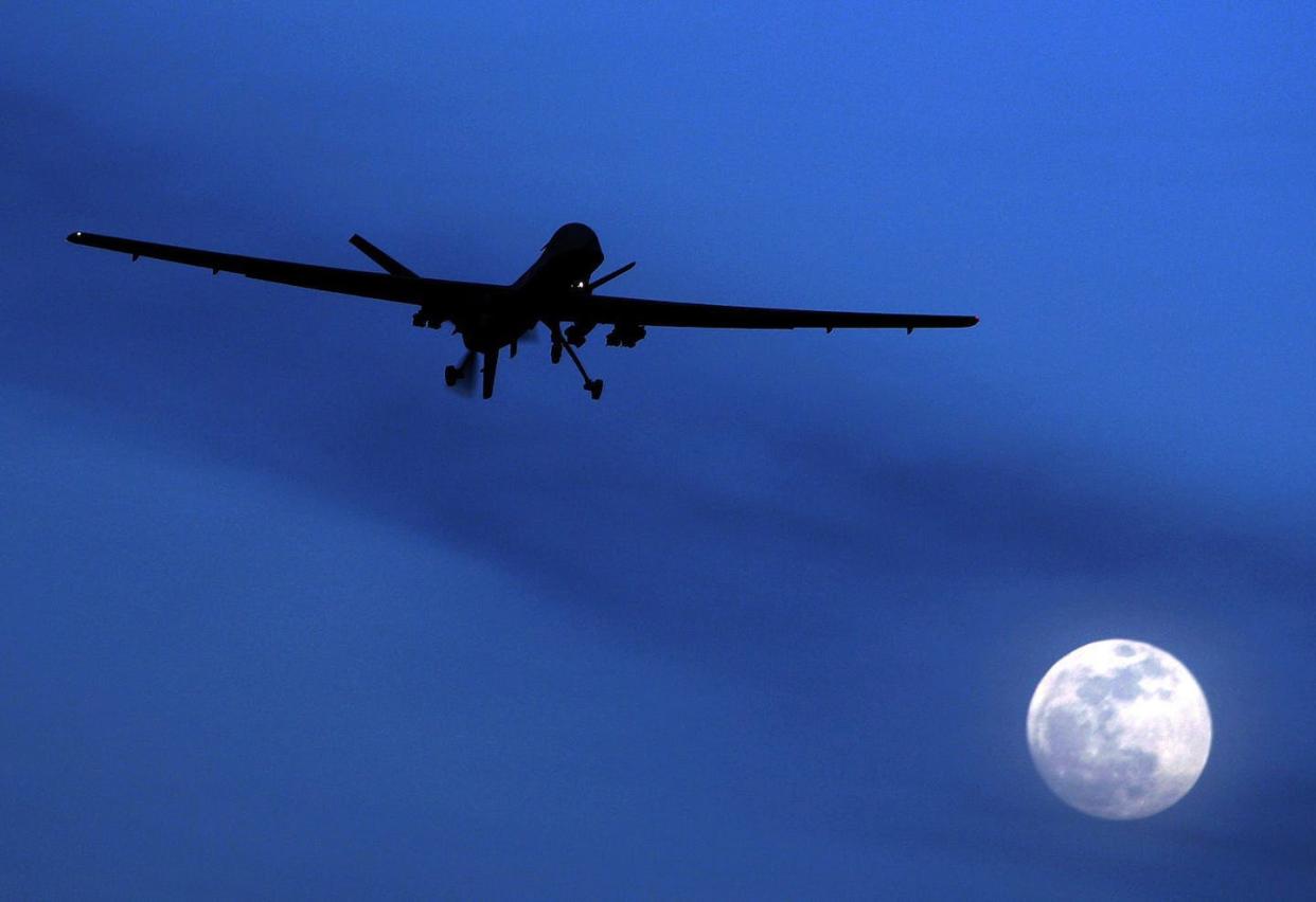 An unmanned U.S. Predator drone flies over Kandahar Air Field, southern Afghanistan, on a moon-lit night several years ago. Drone strikes are now a major feature of modern warfare, including in Ukraine and Syria. (AP Photo/Kirsty Wigglesworth)