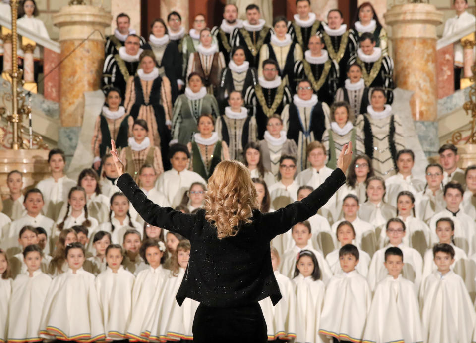 A conductor directs a choir at the Romanian Atheneum concert hall in Bucharest, Romania, Thursday, Jan. 10, 2019, before an event marking the official start of the Romanian Presidency of the Council of the European Union. (AP Photo/Vadim Ghirda)