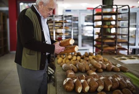 A customer checks loaves of bread at a bakery in the southern Israeli city of Ashkelon December 18, 2014. REUTERS/Amir Cohen