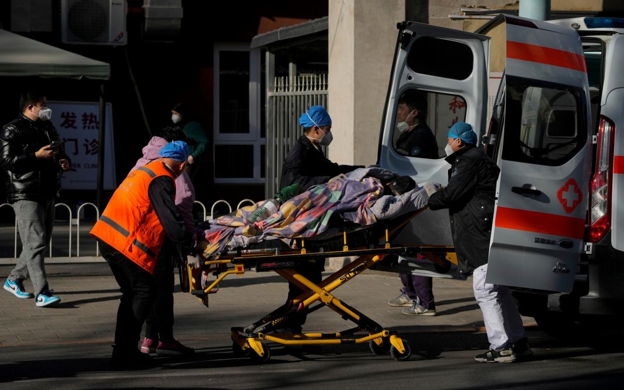 A patient is wheeled into a fever clinic at a hospital in Beijing on Monday - Andy Wong/AP