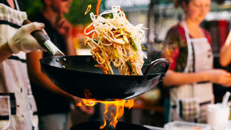 Man cooking stir fry in wok