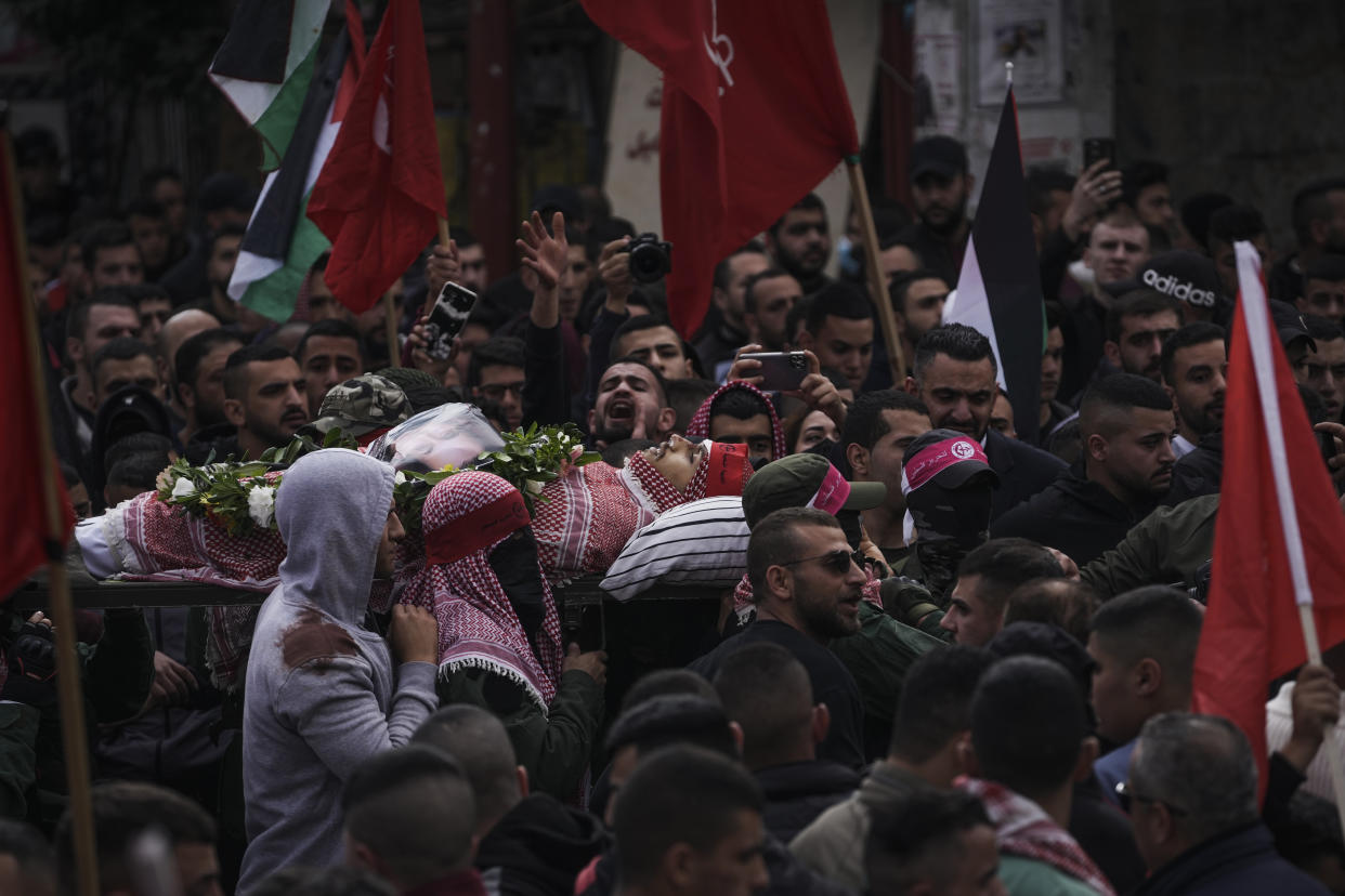 Palestinian mourners carry the body of Omar Manaa during his funeral in the West Bank refugee camp of Deheishe near Bethlehem, Monday, Dec. 5, 2022. Palestinian health officials say Manaa, a 22-year-old Palestinian man, was killed by Israeli fire during a military raid in the occupied West Bank. The army said it opened fire after a crowd attacked soldiers with stones and firebombs. (AP Photo/Mahmoud Illean)