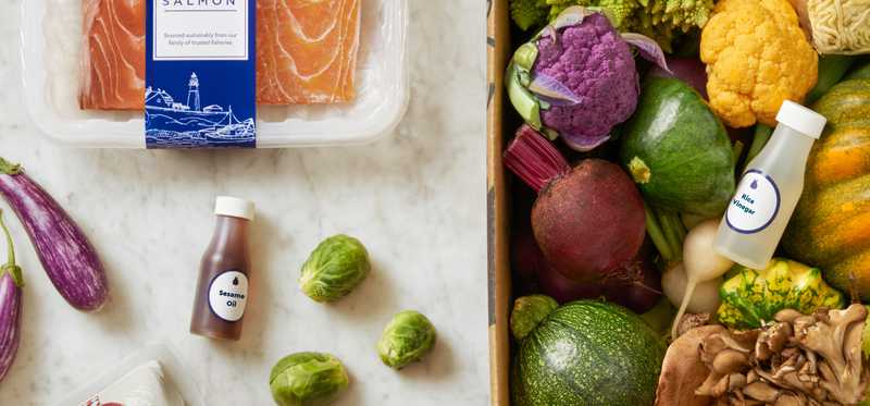 A variety of fresh food ingredients displayed around a box.