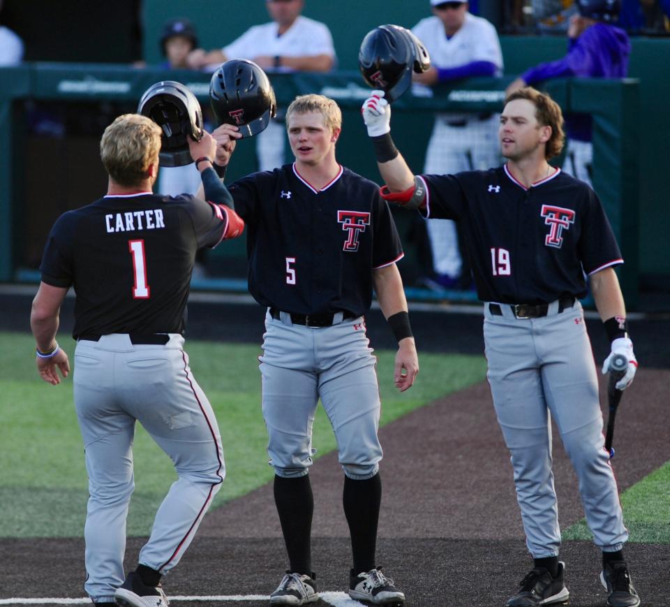 Texas Tech&#39;s Hudson White (middle) and Easton Murrell (right) congratulate Dillon Carter after hitting a home run against ACU.